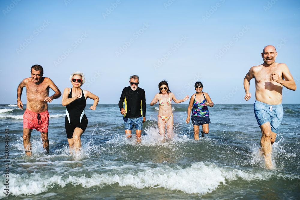 Senior friends enjoying the beach in the summertime Senior friends enjoying the beach in the summertime