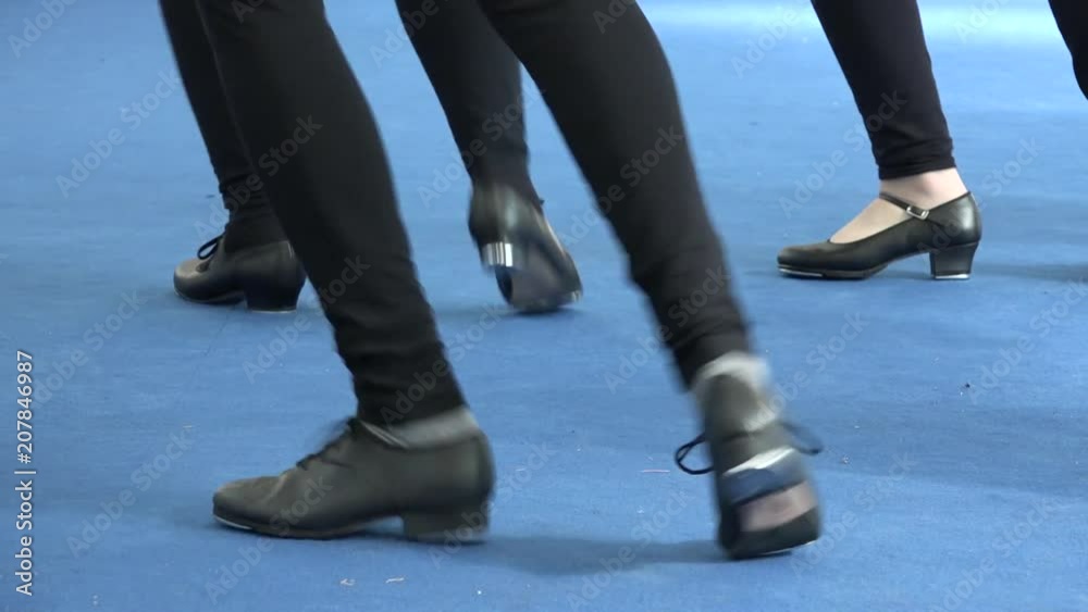 People dancing together tap dance at musical festival. Tappers striking on blue floor. Close up of tap shoes, shiny light on carpet background. Vintage dance style, leisure and musical culture People dancing together tap dance at musical festival. Tappers striking on blue floor. Close up of tap shoes, shiny light on carpet background. Vintage dance style, leisure and musical culture
