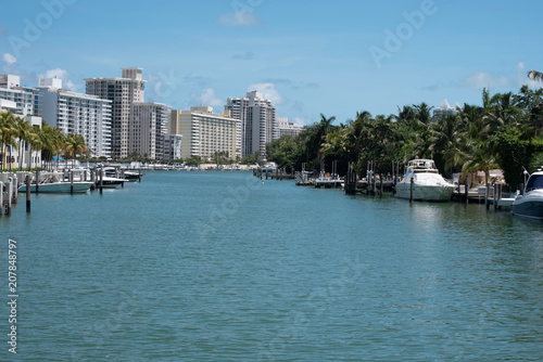 Miami canal with boats and palm trees blue sunny day © Love