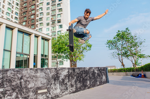 Young man on a skateboard jumping high and making trick
