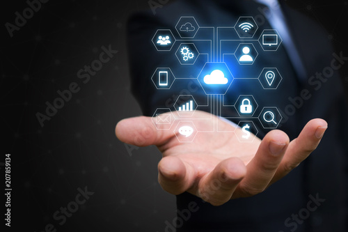 Businessman holding cloud button and icon. Business and technology concept.