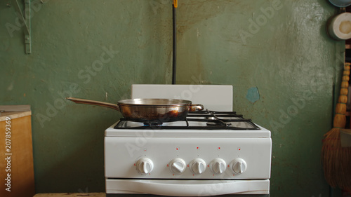 Steel pan on a gas stove in an old kitchen of a communal flat photo