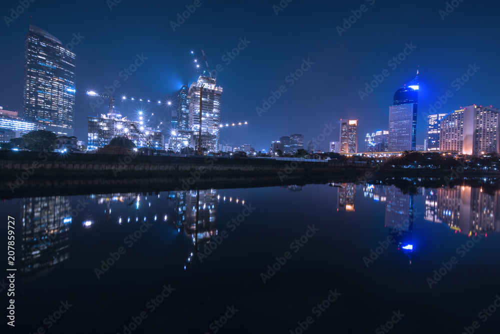 Beautiful reservoir with glow lights on skyscrapers