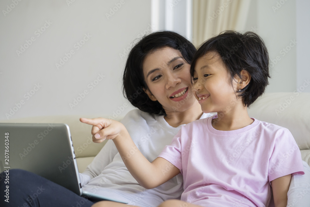 Mother guide her daughter for using a laptop Mother guide her daughter for using a laptop