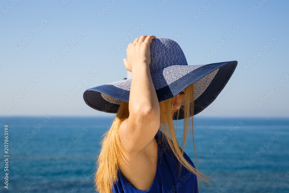 Fototapeta premium Pretty blond woman in the blue dress at the beach in Cyprus.