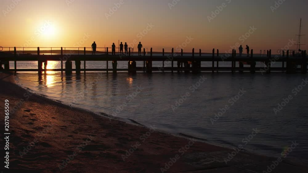 A full shot of silhouette people on the pier A full shot of silhouette people on the pier