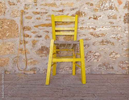 yellow chair on stone wall background
