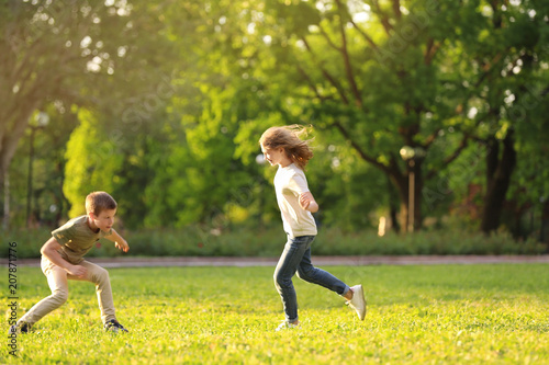 Cute little children playing together outdoors on sunny day