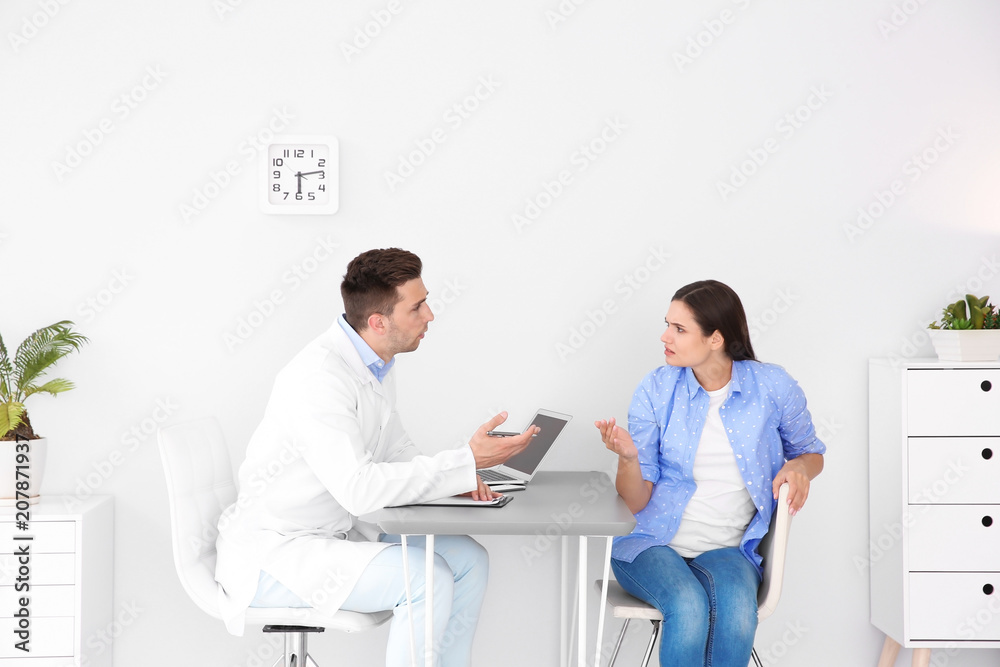 Fototapeta premium Depressed young woman having appointment with psychologist in office