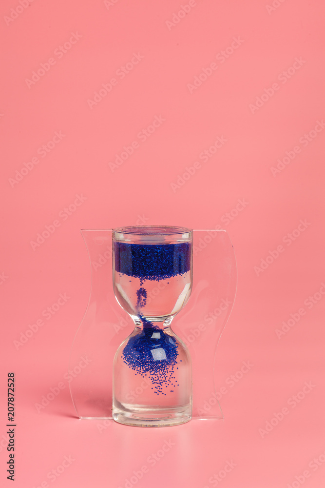 Close up of hourglass against pink background Close up of hourglass against pink background