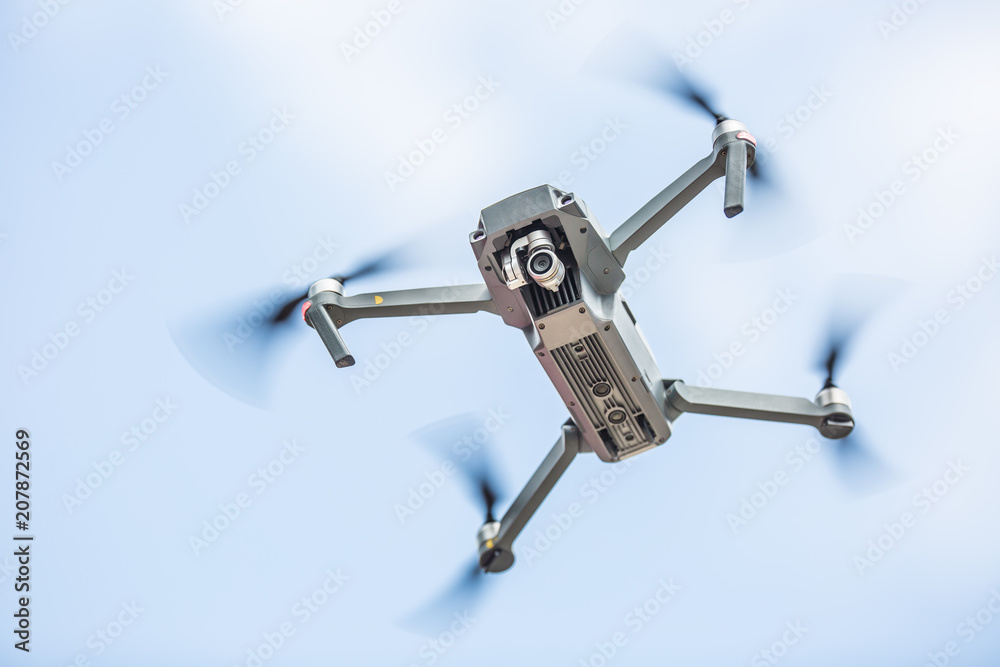 Close-up quadcopter drone with camera flying in park