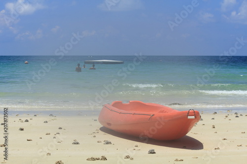 red kayak on the white sand beach