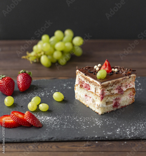 Delicious cake with strawberries  grapes  chocolate