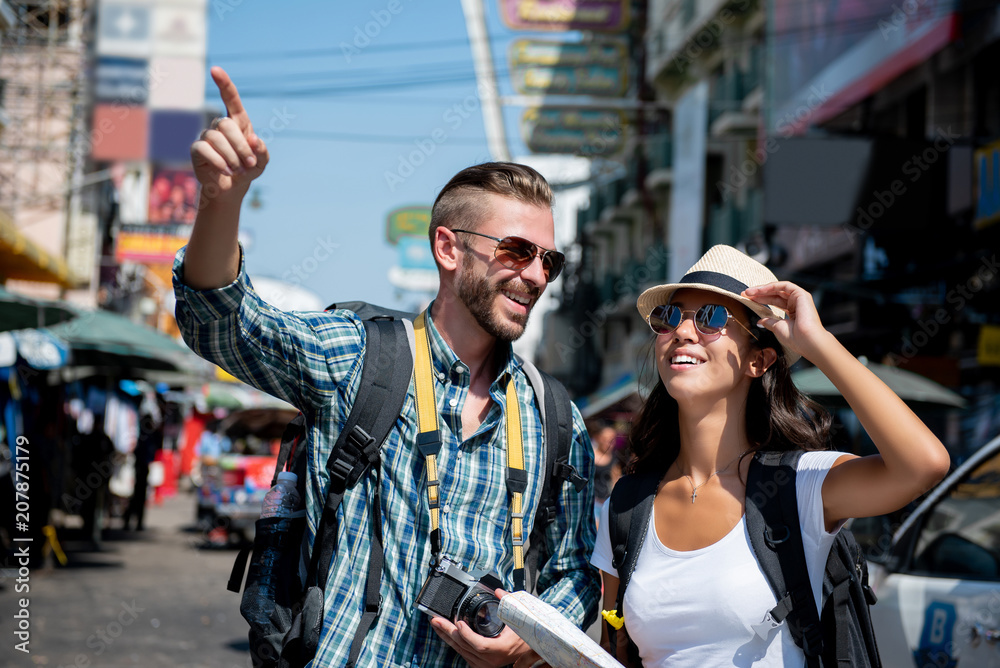 Obraz premium Interracial tourist backpacker couple traveling in Bangkok Thailand