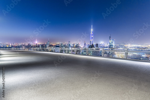 Panoramic skyline and buildings with empty road at night