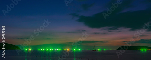 Sunset on the island of Langkawi. Lights of fishing boats. Malaysia.