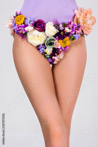 cropped shot of young woman in panties made of beautiful tender flowers isolated on grey