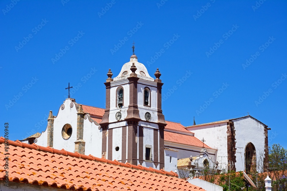 View of the Gothic cathedral (Igreja da Misericordia) and bell tower seen over rooftops, Silves, Portugal.
