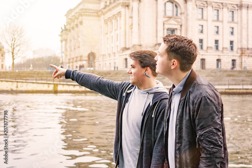Canvas Print two male tourists exploring government district with Reichstag building and Spre