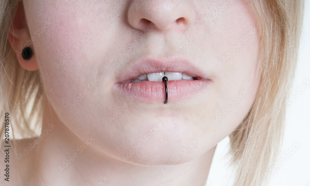 pierced female lips with vertical labret piercing or lip ring on middle  lower lip Stock-bilde | Adobe Stock