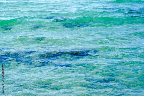 Clear water background, blue natural texture. Sea wave close up, low angle view.