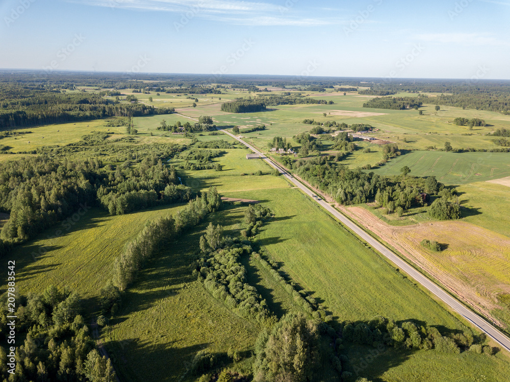 drone image. aerial view of countryside road network, cultivated fields and forest textures