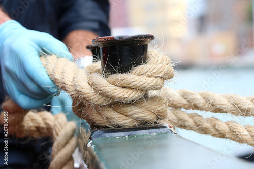close-up of a sailor's hand making a mooring knot