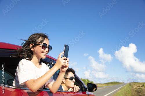 Happy family enjoy road trip taking picture by smart phone