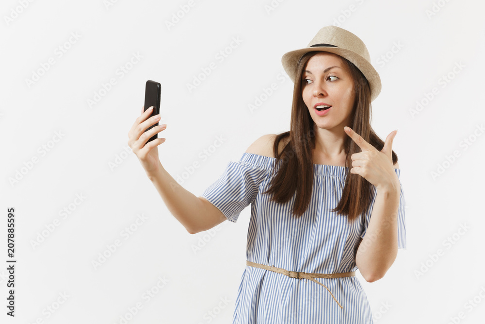 Young beautiful woman dressed blue dress, hat doing selfie shot on mobile phone or video call isolated on white background. People, sincere emotions, lifestyle concept. Advertising area. Copy space. Young beautiful woman dressed blue dress, hat doing selfie shot on mobile phone or video call isolated on white background. People, sincere emotions, lifestyle concept. Advertising area. Copy space.
