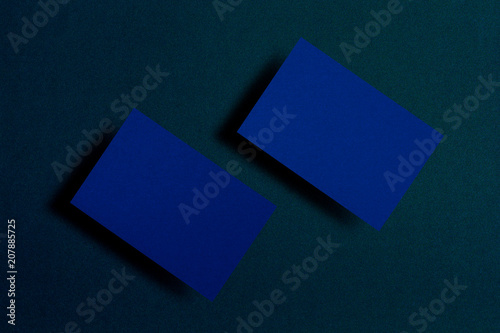 Mock up of two horizontal blue business cards at dark blue textured paper background. Mock-up template for branding identity. For graphic designers presentations and portfolios