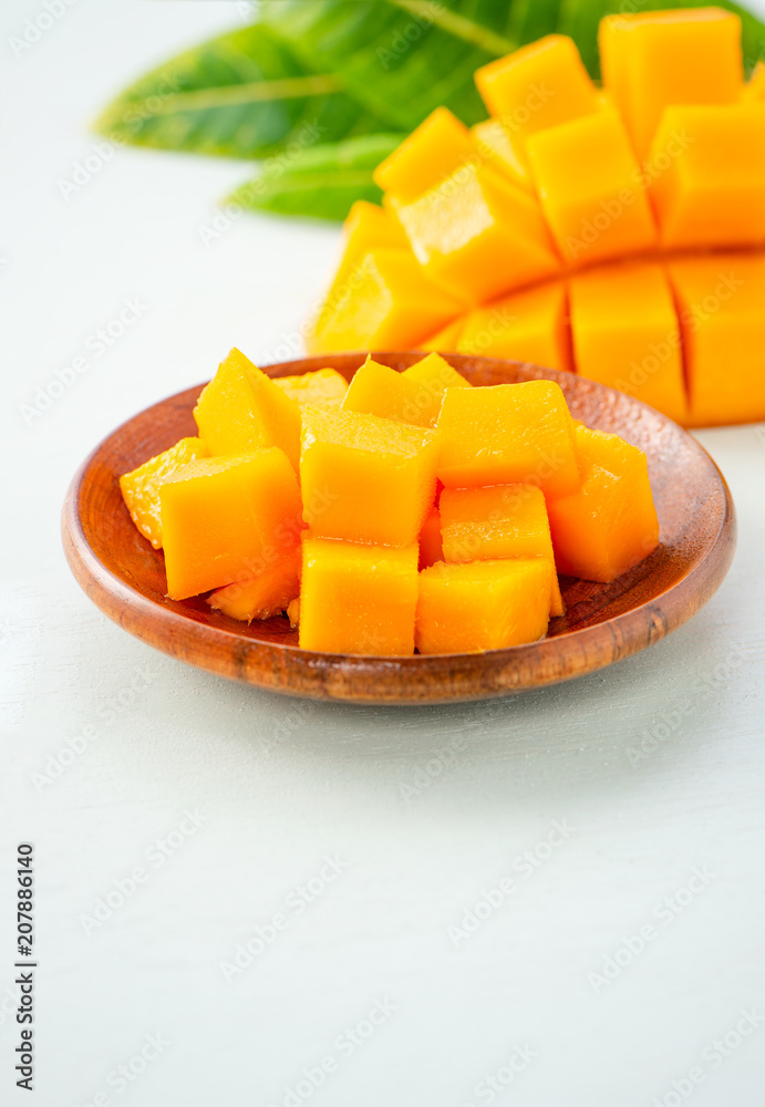 Fresh and beautiful mango fruit with sliced diced mango chunks on a light blue background, copy space(text space), blank for text.