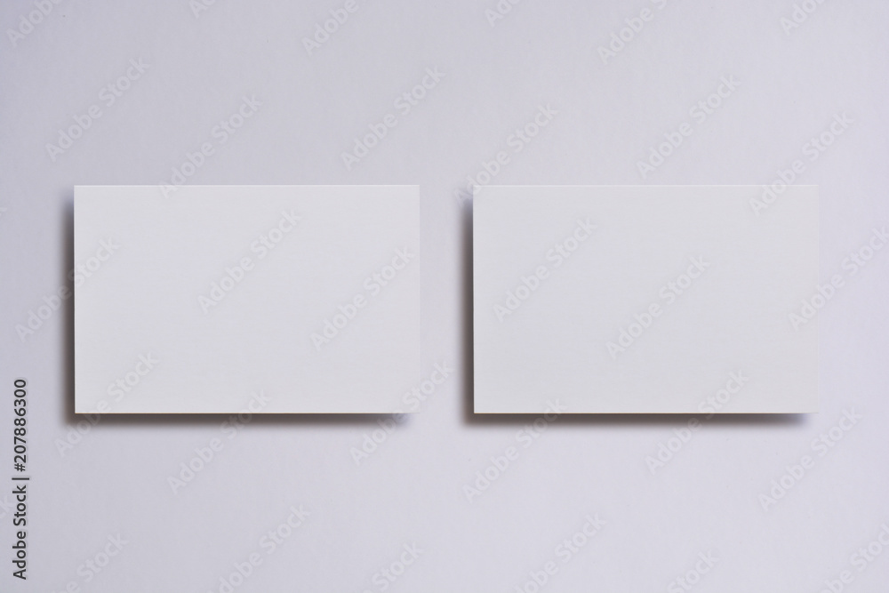 Photo of blank white business cards on white. Mock-up for branding identity. For graphic designers presentations and portfolios