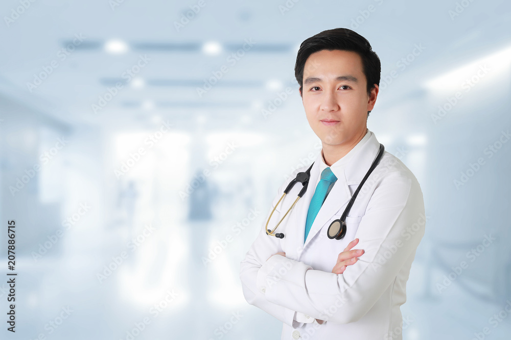 Doctor posing with arms crossed, medical staff working on blurry background. Doctor posing with arms crossed, medical staff working on blurry background.