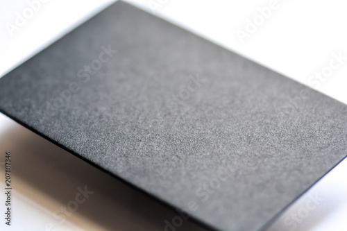 Mockup of blank textured black business card at white background