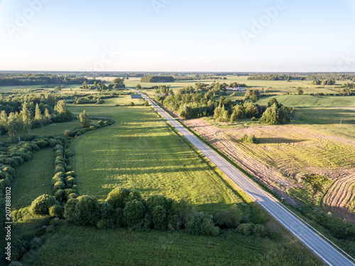 drone image. aerial view of countryside road network, cultivated fields and forest textures © Martins Vanags
