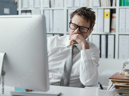 Pensive businessman staring at the computer screen