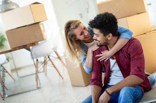 Young couple Moving in new home and unpacking carboard boxes © NDABCREATIVITY
