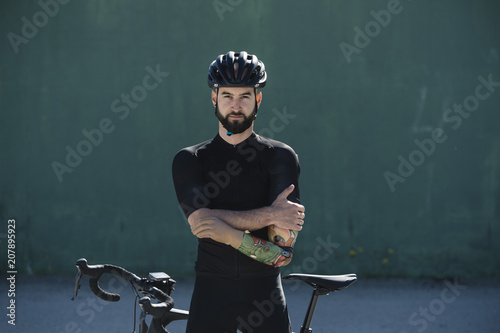 Portrait of handicapped cyclist  standing against his bicycle photo