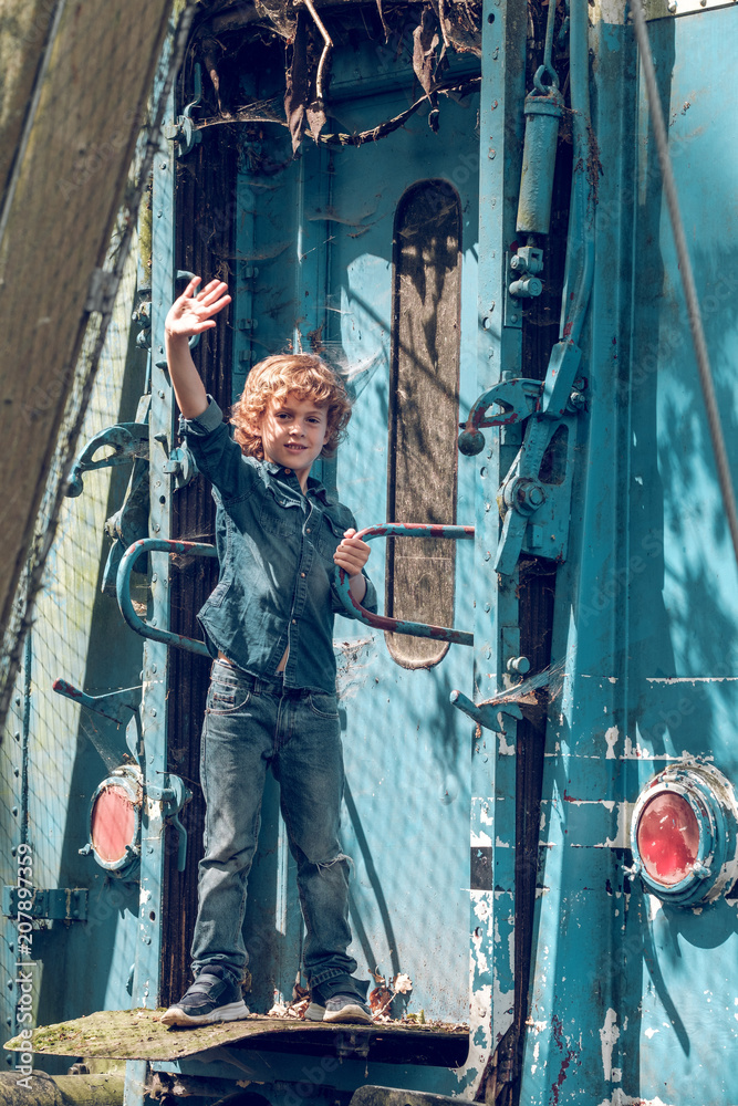 Kid in denim standing outside of wagon Kid in denim standing outside of wagon