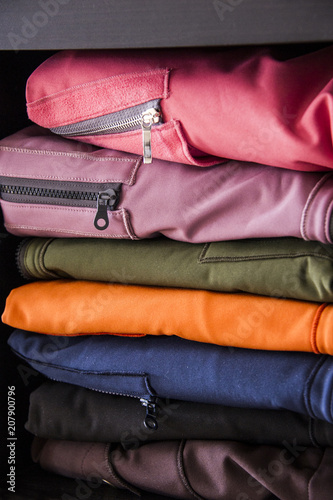 Various colorful softshell coats on a shop shelf. Sporty design.