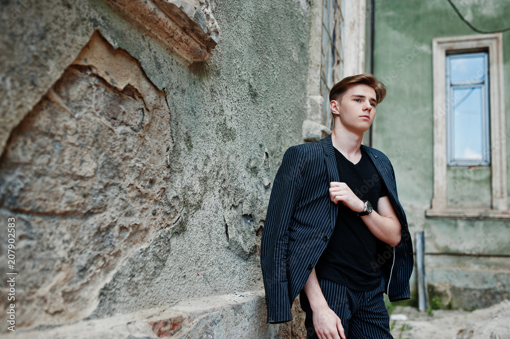 Young stylish macho boy in black jacket posed outdoor of street. Amazing model man. Young stylish macho boy in black jacket posed outdoor of street. Amazing model man.