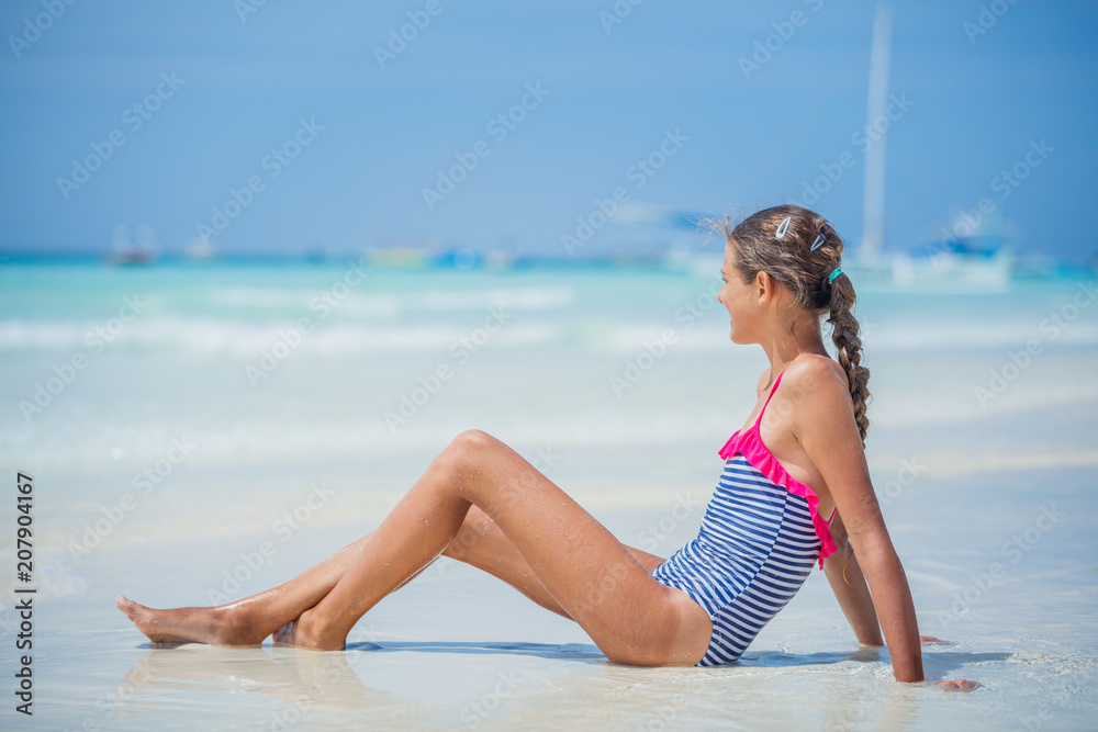 Girl in bikini lying and having fun on tropical beach