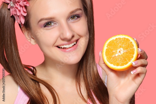 Young girl posing with halves of orange