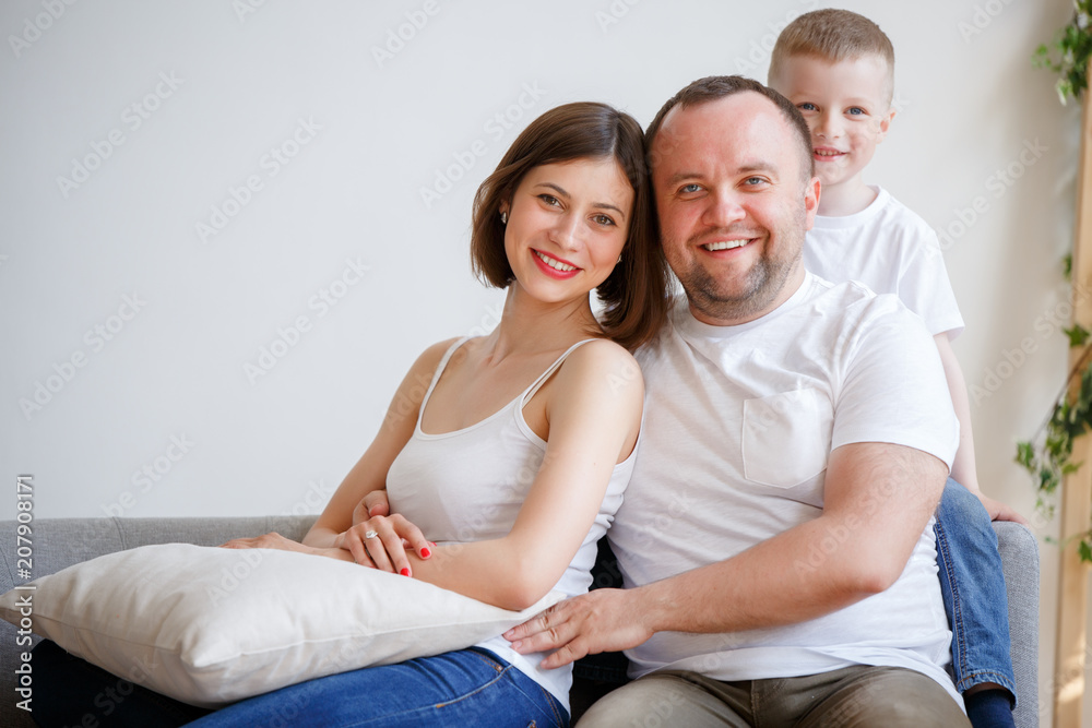 Portrait of cuddling parents with son sitting on sofa Portrait of cuddling parents with son sitting on sofa