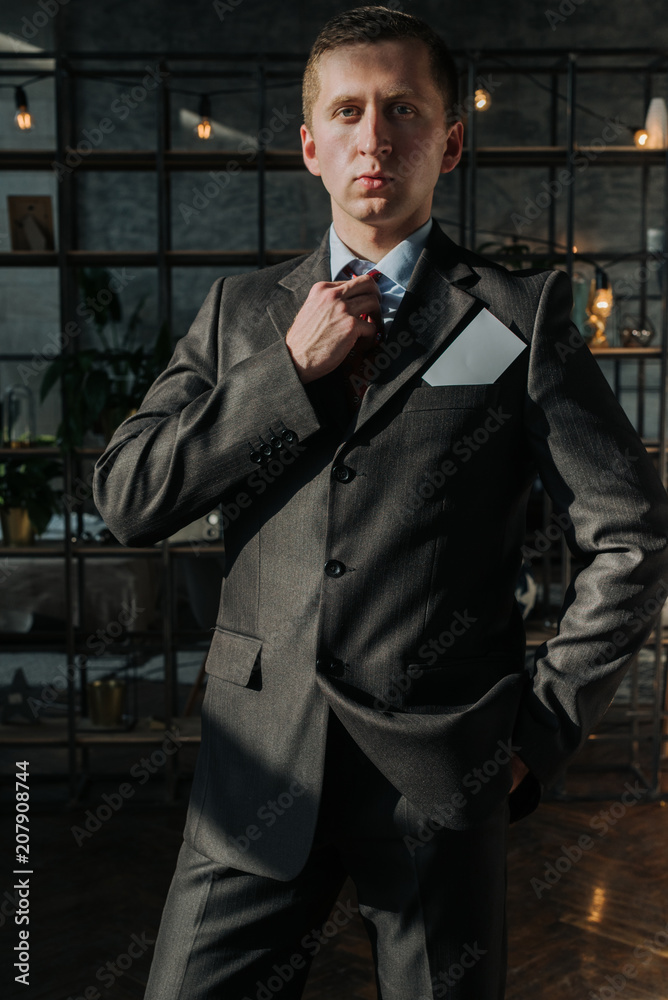 Businessman in suit holding empty business card.Man in business suit showing blank card Businessman in suit holding empty business card.Man in business suit showing blank card