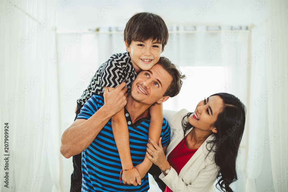 Portrait happy family father, mother and son, child boy playing together in bed room