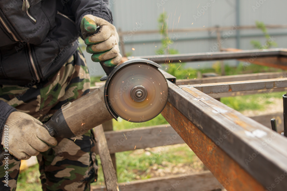 Worker cuts metal for doors at a construction site Worker cuts metal for doors at a construction site