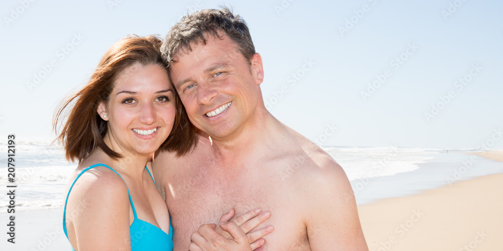 Happy romantic couple on the beach at sunset embracing each other Happy romantic couple on the beach at sunset embracing each other