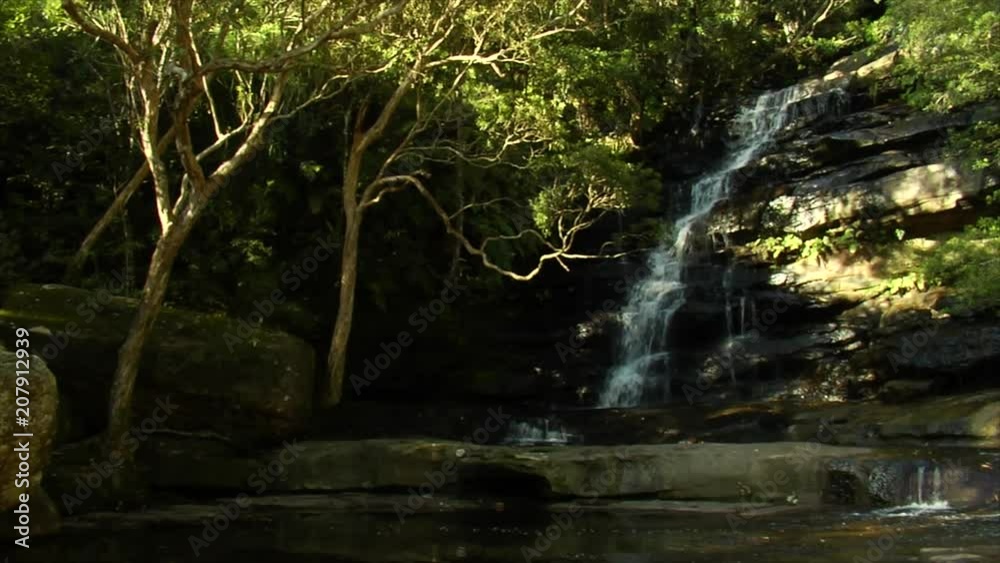 Slow motion film of large Australian waterfall in the middle of the bush. Slow motion film of large Australian waterfall in the middle of the bush.
