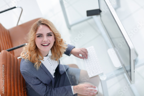 smiling business woman sitting behind a Desk